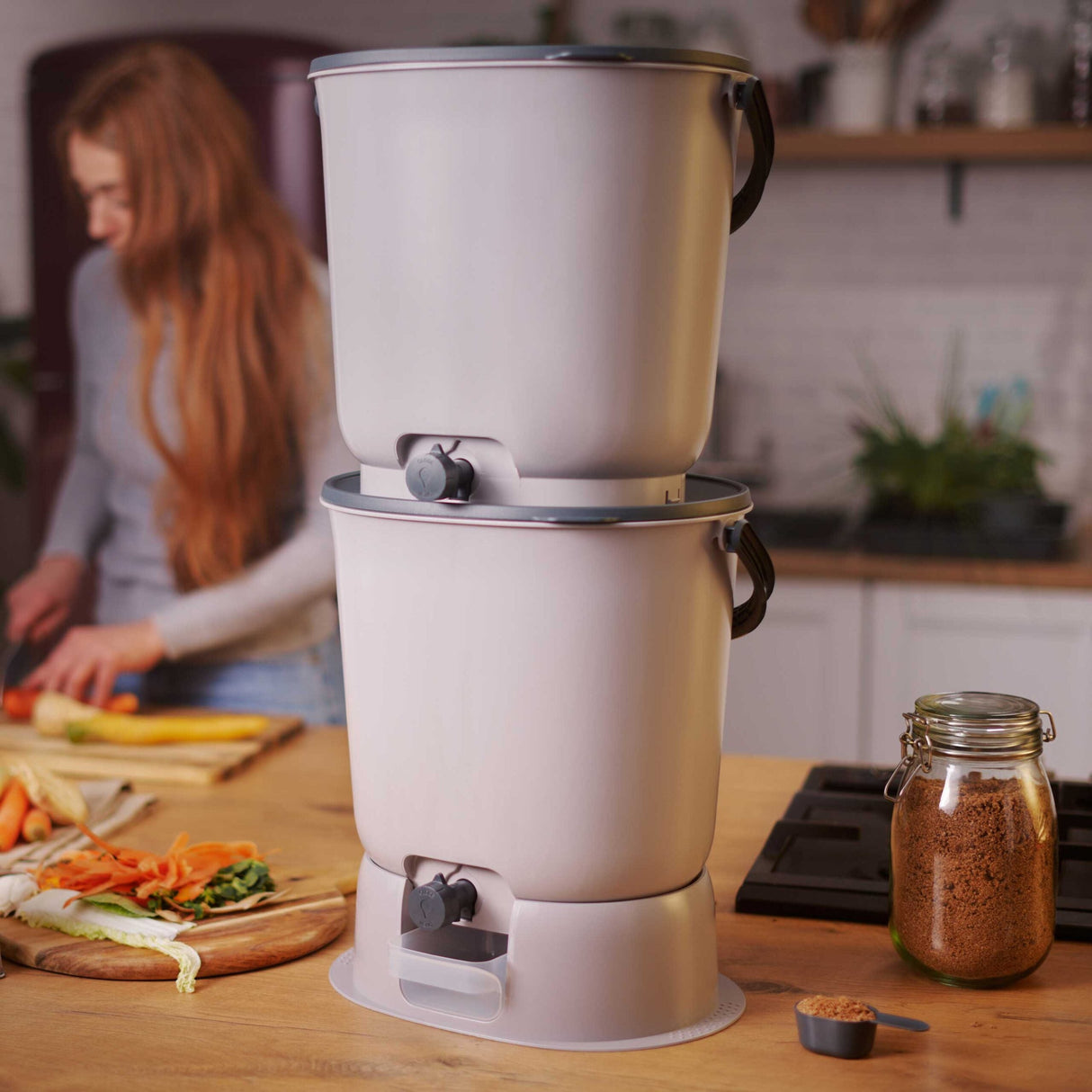 Viser 2 stk Bokashi Essence Kompostbøtter i lys gråfarge, inkl. 1 kg Bokashi-strø - effektiv kompost av kjøkkenavfall.