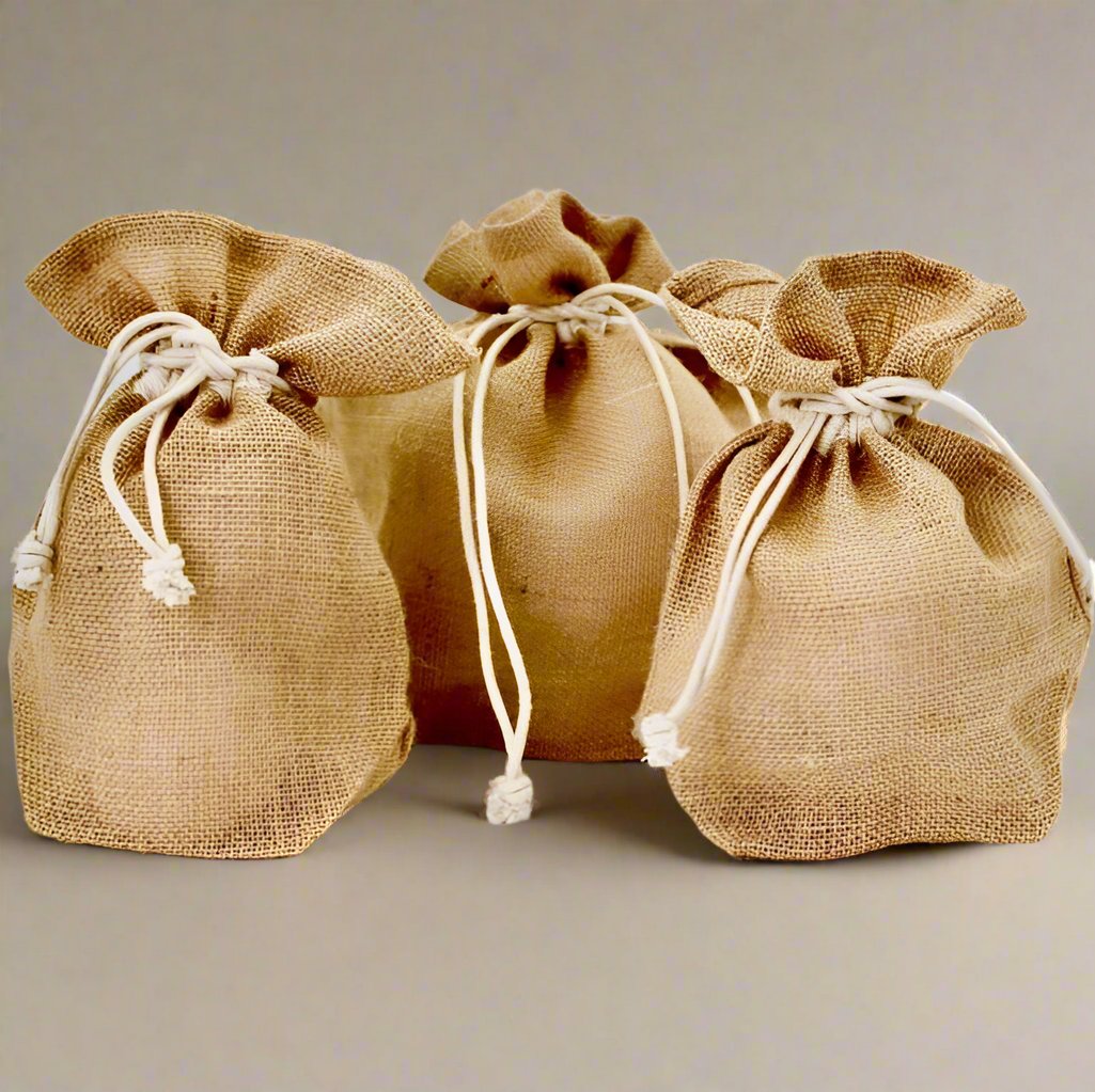 Suztain gavepose i jute med snørelukking, stor størrelse 25x20x10 cm, naturlig farge på gavebord.
