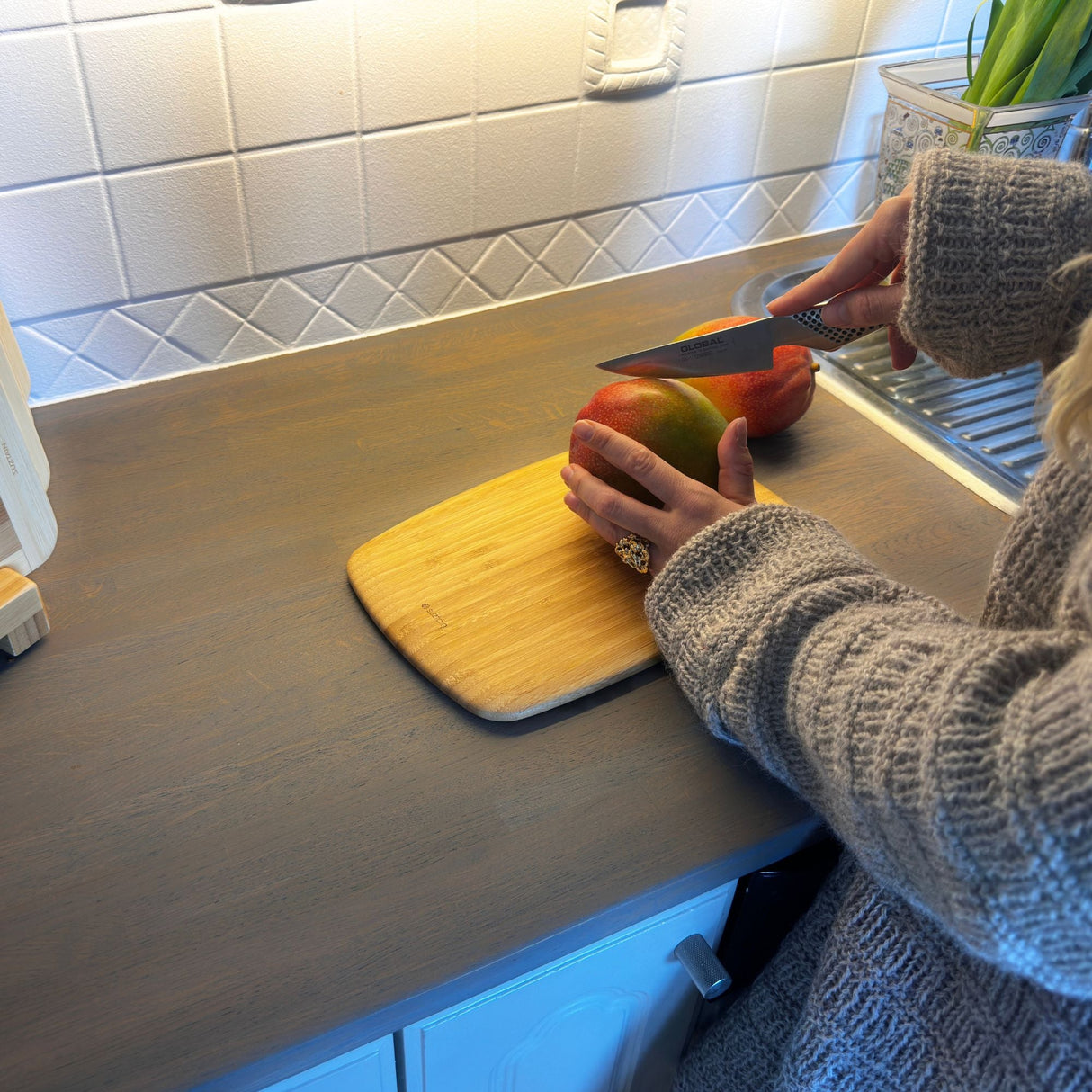 Person holder Suztain skjærebrett – viser størrelse og grep.