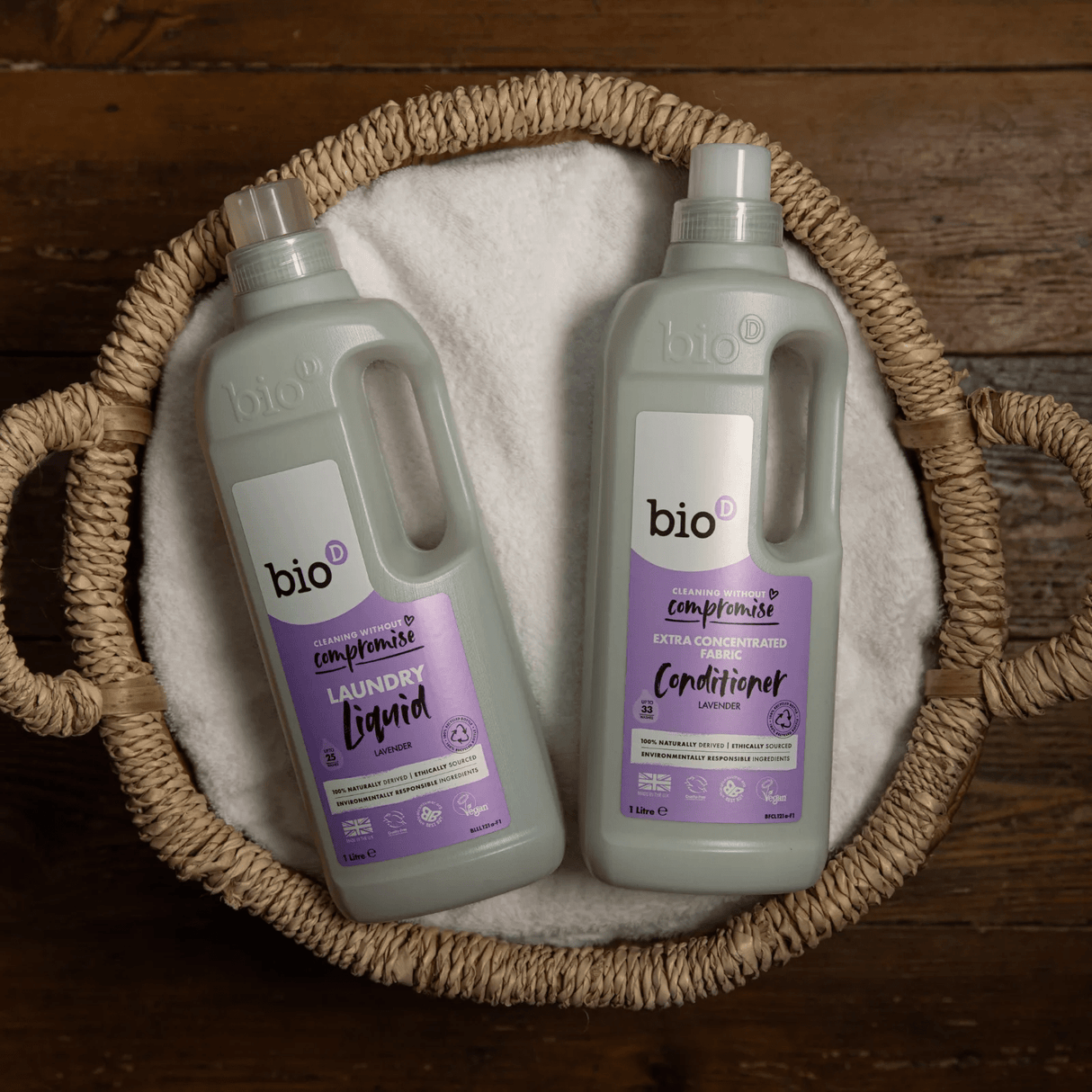 Bio-D flytende vaskemiddel lavendelduft 1 liter i plastflasker i flettet kurv på trebenk