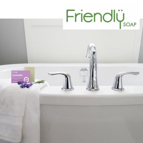 Friendly Soap såpestykke Lavendel 95g i lilla emballasje og grønn såpe, i bruk på et baderom