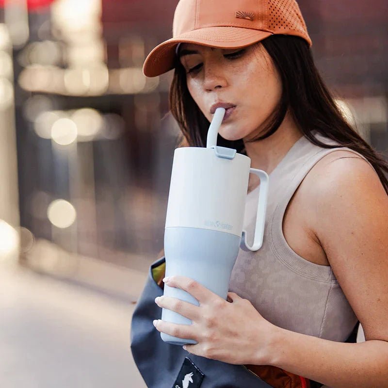 Klean Kanteen Rise Tumbler 1065 ml Ice Blue i rustfritt stål, i bruk av en person utendørs