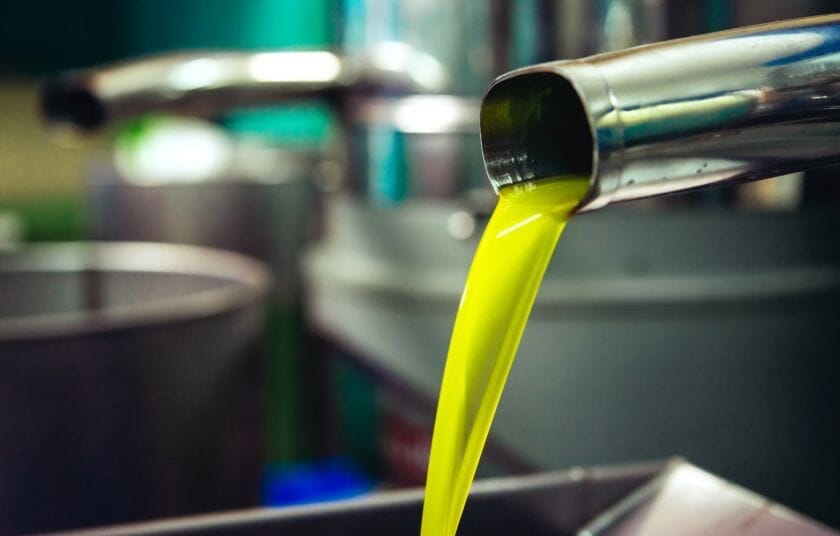 Protogerakis økologisk olivenolje 1 liter i rustfritt stål, nærbilde av olivenolje som helles ut av tappekran