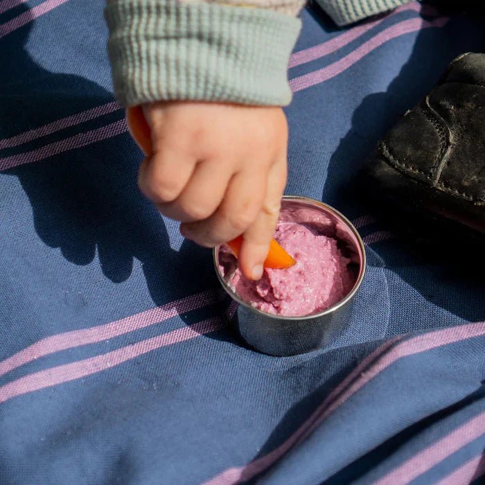 Pulito Pure Dip Box 50 ml i rustfritt stål, fylt med rosa dipp og gulrot, nærbilde av barnets hånd