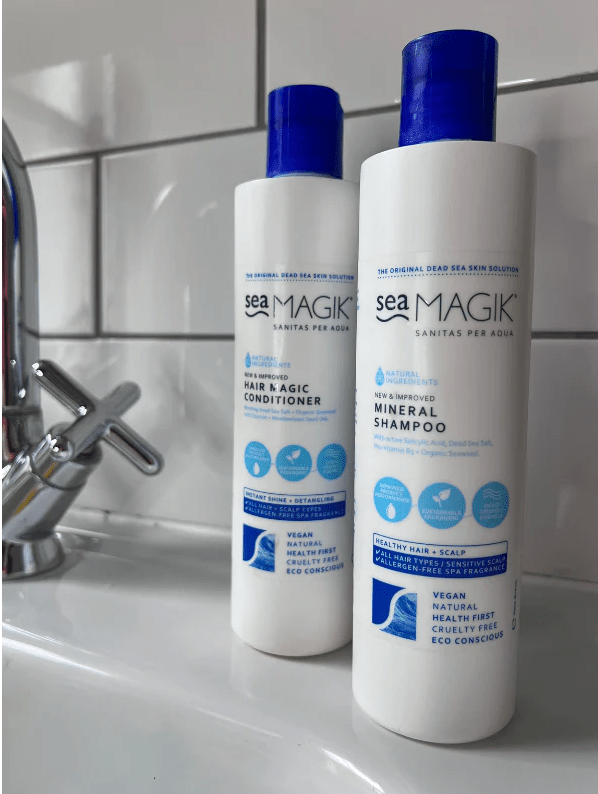 Sea Magik Mineral Sjampo 300 ml og Balsam 300 ml hvite i plastflasker, i bruk på baderomsvask