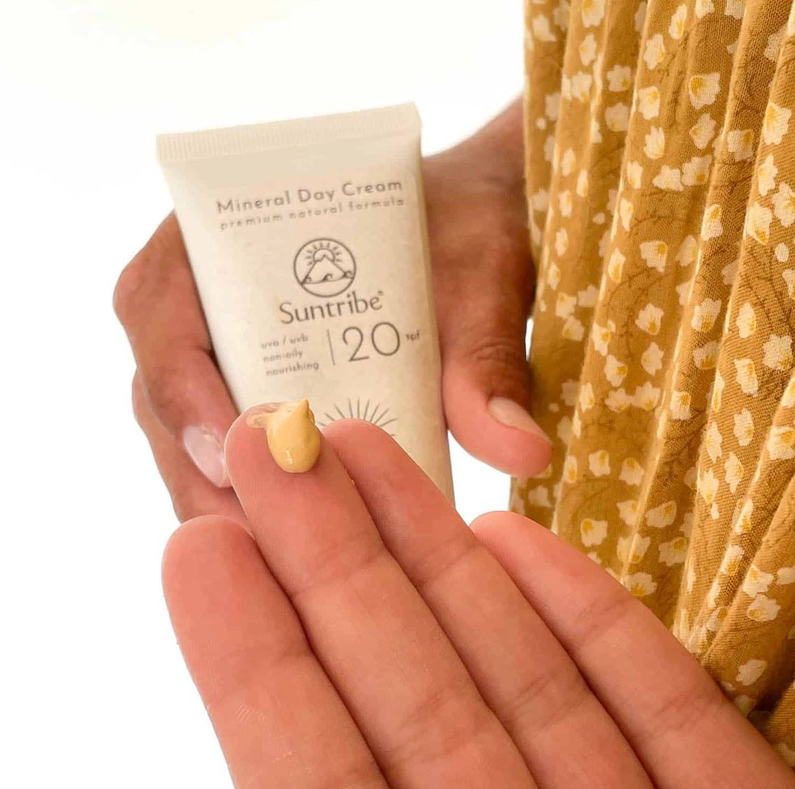 Suntribe ansiktskrem med solfaktor SPF 20 Tinted 50 ml i plasttube, med en dråpe krem på fingeren