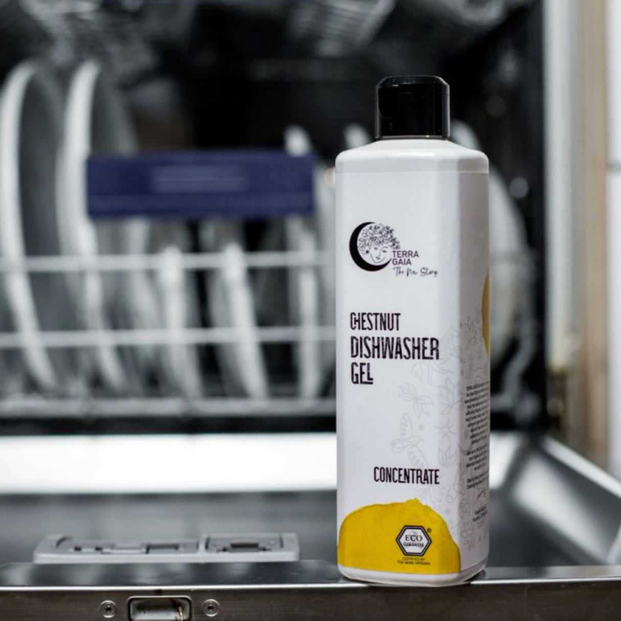 Terra Gaia Oppvaskmaskin Gel 500ml Sitrus i plastflaske, plassert foran en åpen oppvaskmaskin