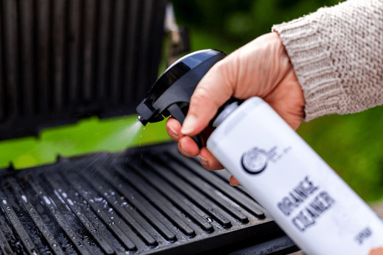Terra Gaia Rengjøringsspray Økologisk 500ml appelsin i hvit plastflaske, i bruk på grillrist utendørs