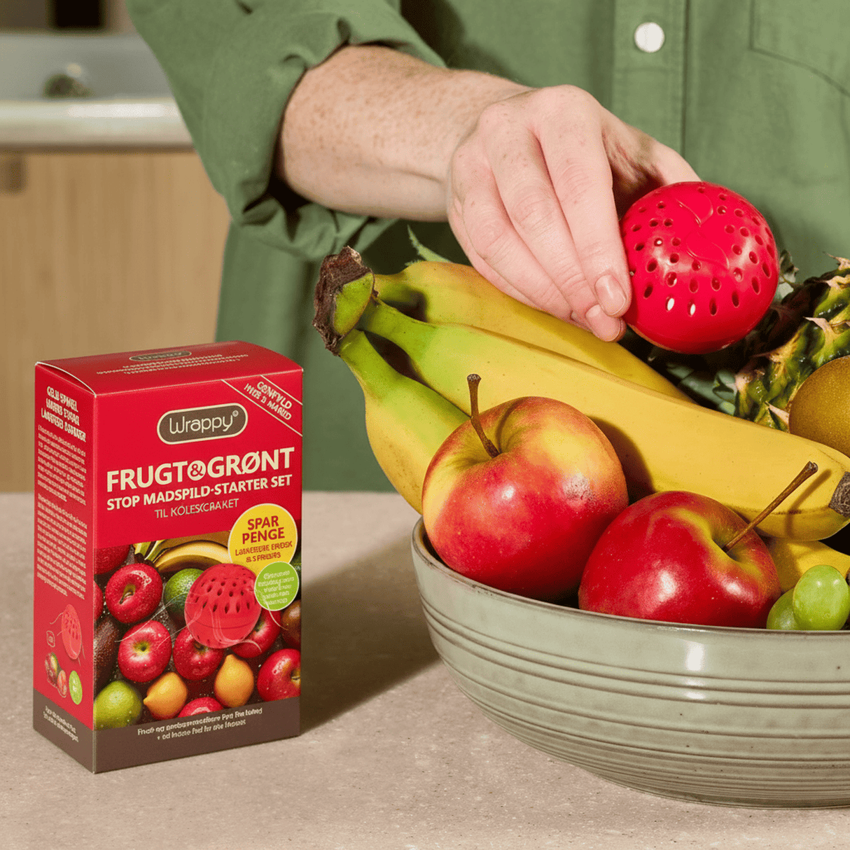 Wrappy® Pods – Frisk & Sprø Startpakke ved siden av fruktfat med røde epler og bananer på kjøkkenbenk