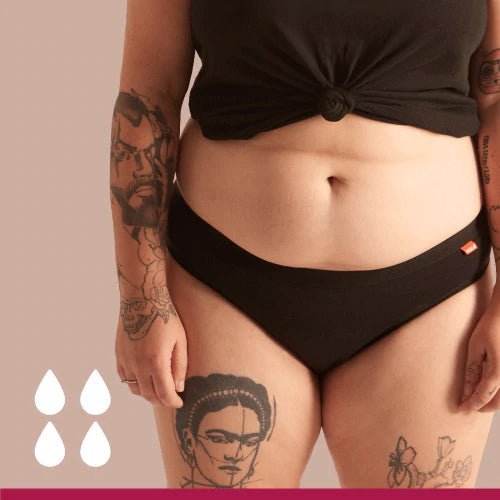 WUKA Basics Hipster Medium Flow i svart bomull, sett forfra på en modell med tatoveringer