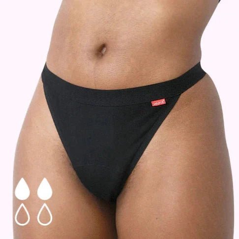 WUKA Basics™ Thong Light Flow i svart bomull på en modell, med to fylte og to tomme dråper
