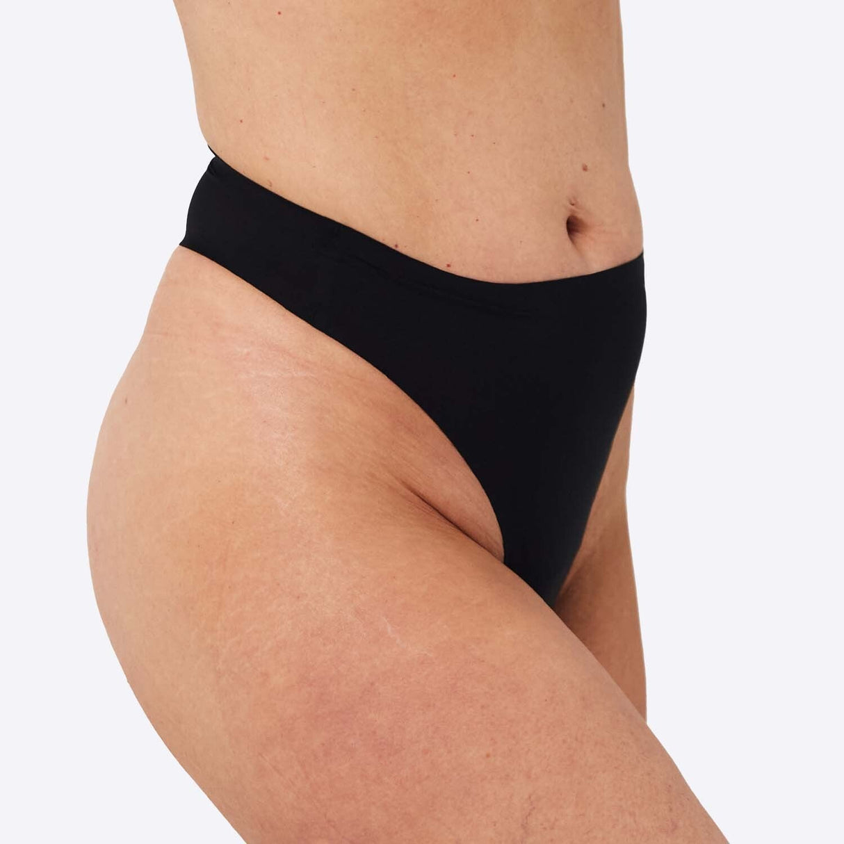 WUKA Stretch Thong Light/Medium flow svart i tekstil, modell iført trusen sett fra siden