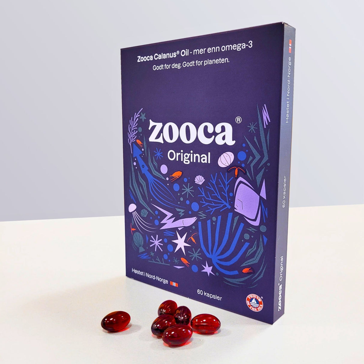 Zooca Original Omega-3 60 kapsler i lilla eske med maritimt design og røde kapsler på hvit bakgrunn