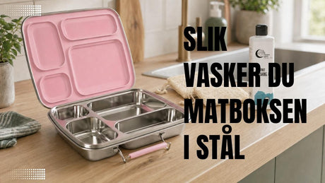 Åpen rosa matboks i rustfritt stål med fire rom står ved kjøkkenvasken sammen med oppvaskmiddel og myk oppvaskbørste, klar for skånsom rengjøring