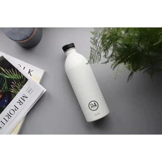 24Bottles Urban Drikkeflaske 1000 ml Ice White i rustfritt stål, liggende på grått underlag