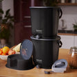 Bildet viser 2 stk Bokashi Essence Kompostbøtter i sort, inkl. 1 kg Bokashi-strø- for effektiv hjemmekompostering.