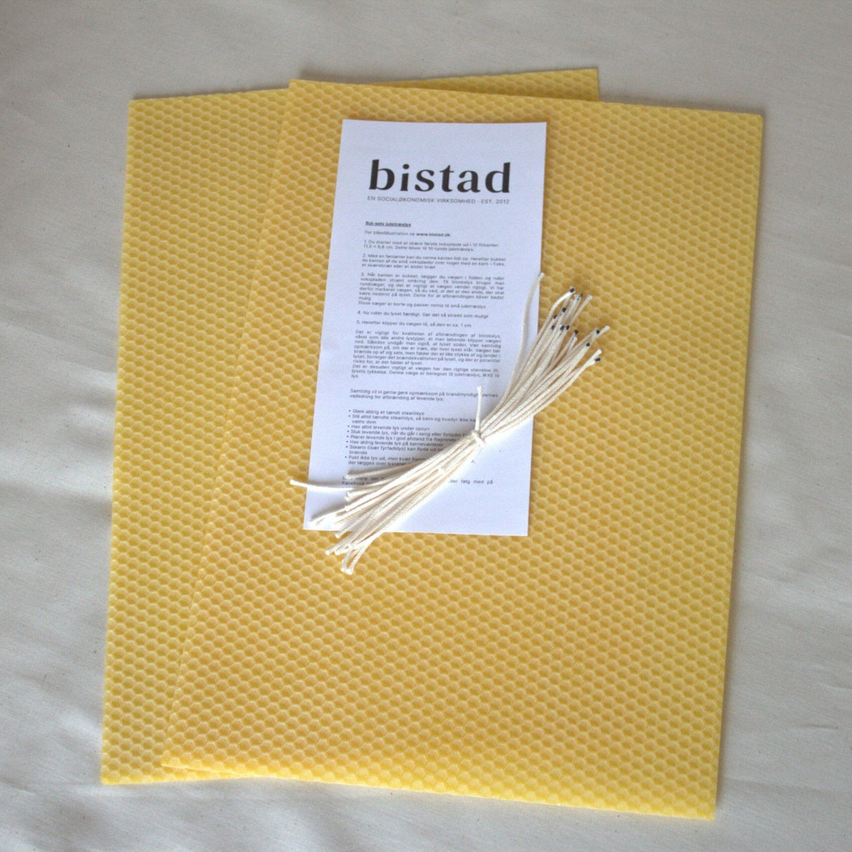 Bistad rull selv bivokslys, bordlys, gule i bivoks, med voksark, veker og instruksjonshefte sett ovenfra