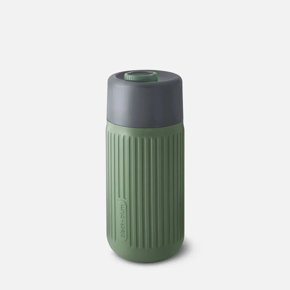 Black+Blum Glass Travel Cup 340 ml Olive i glass og silikon, sett fra siden med logo nederst