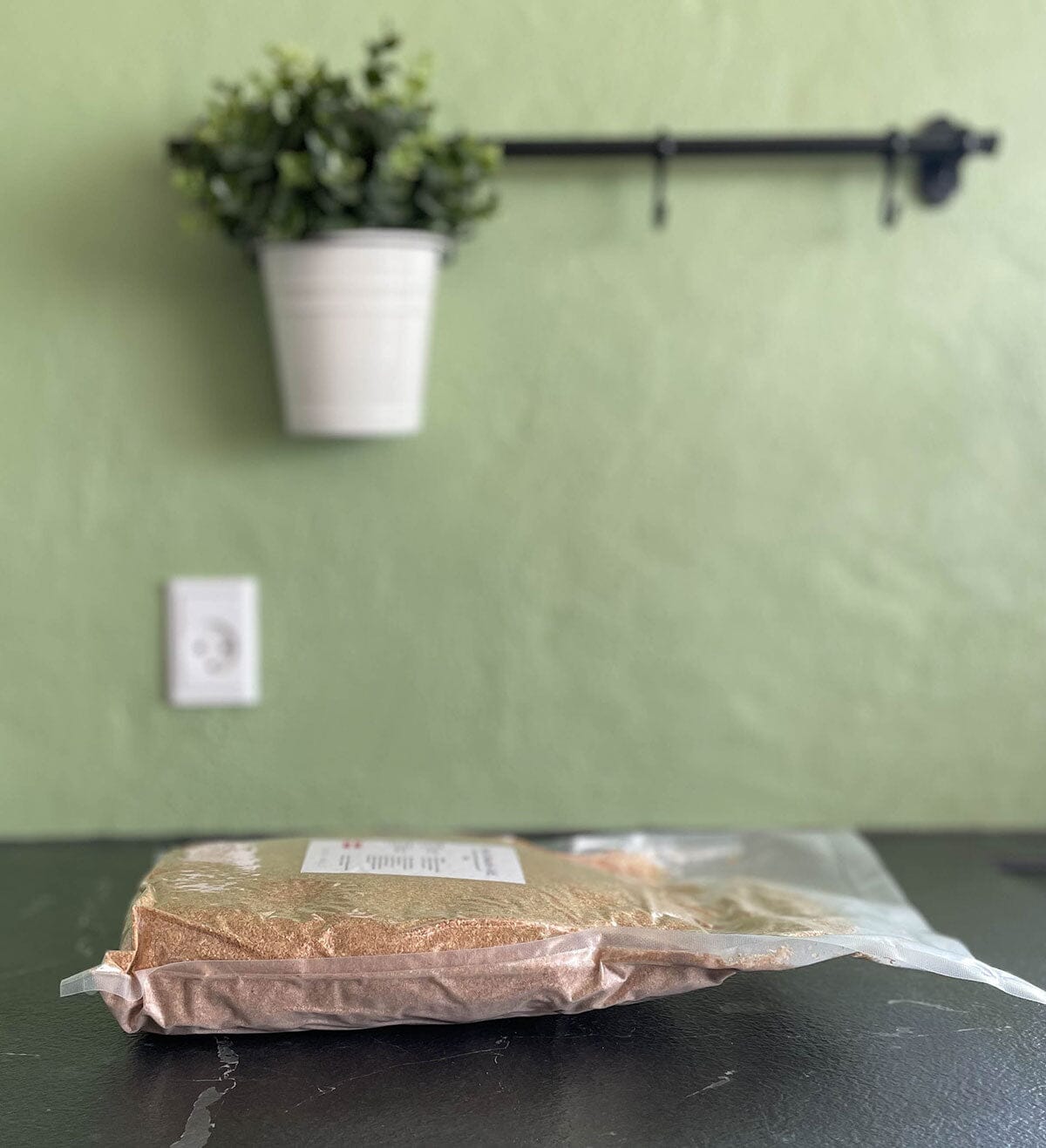 Bokashi Bokashistrø 1kg i gjennomsiktig plastpose liggende på kjøkkenbenk, sett fra siden