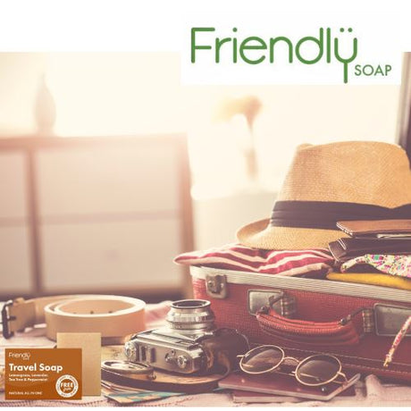 Friendly Soap reisesåpe 95g i lavendel, sitrongress, mynte og tea tree, i bruk på et bord med reiseutstyr