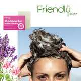 Friendly Soap Sjampobar Lavendel & Geranium 95g i hvit med rosa emballasje, i bruk på en person som vasker håret
