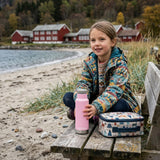 Klean Kanteen Isoleret Classic 355 ml Lotus i rustfritt stål, i bruk av barn på en benk ved stranden
