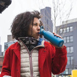 Klean Kanteen Classic Drikkeflaske 532ml Sea Spray i rustfritt stål, i bruk av person i bymiljø
