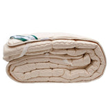Læsø Garnspinderi Ull overmadrass 90x200 cm beige i ull, sammenrullet og sett fra siden