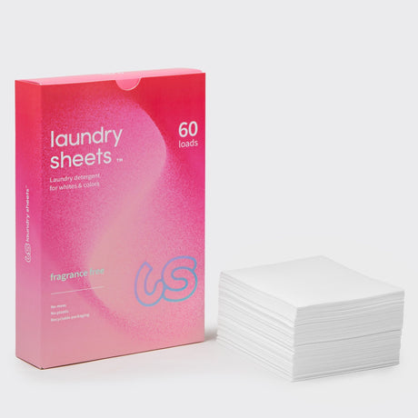 Laundry Sheets tøyvask 60 ark uten duft i rosa eske av papp, med en stabel hvite ark ved siden av
