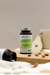 Natures Own Magnesium 60 tabletter i brun glassflaske med grønn etikett, med pære i bakgrunnen