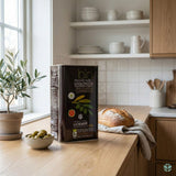 Protogerakis Extra Virgin Olivenolje 3 L i svart metallkanne på kjøkkenbenk med brød og oliven