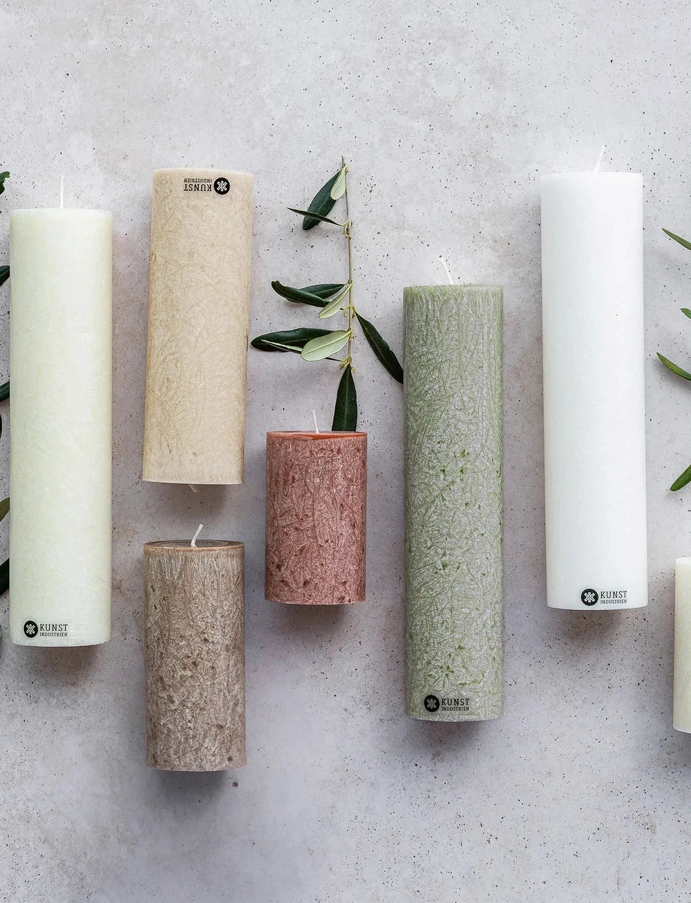 Kunstindustrien kubbelys 18 cm Moss Green i olivenvoks, sammen med flere kubbelys i ulike farger og størrelser