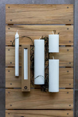 Kunstindustrien Kubbelys 18 cm White i olivenvoks, med andre lys og emballasje på treunderlag