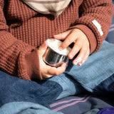 Pulito Pure Dip Box 50 ml i rustfritt stål, fylt med mat og holdt av et barn, nærbilde av hender