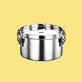 Pulito PureLunchBox Airtight rund 800 ml i rustfritt stål med låsespenner mot gul bakgrunn