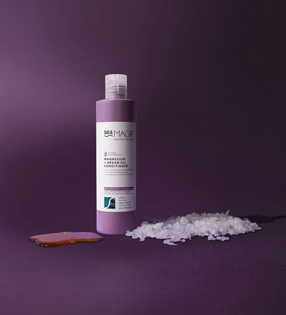 Sea Magik balsam Magnesium og Argan 300 ml lilla i plastflaske, med saltskrubb og balsam på underlaget