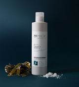 Sea Magik sjampo 3 Seaweed 300 ml grå i plastflaske, med tang og saltkorn på mørk bakgrunn