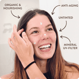 Suntribe Ansiktskrem SPF 20 Untinted 50 ml i kremform, påført i ansiktet på en smilende kvinne