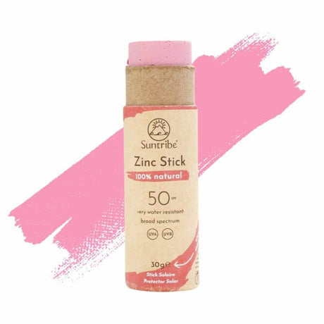 Suntribe solstift SPF 50 Pretty Pink i pappemballasje med rosa bakgrunnsmaling, sett forfra