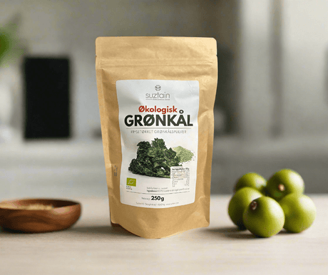 Suztain økologisk frysetørket grønnkålspulver 250g i brun papirpose på kjøkkenbenk med grønne tomater