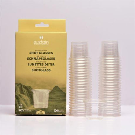 Suztain plastfrie shotglass 48 stk i gjennomsiktig materiale ved siden av eske i gult design
