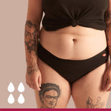 WUKA Basics Hipster Medium Flow i svart bomull, sett forfra på en modell med tatoveringer