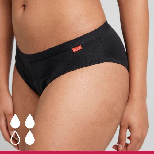 WUKA Basics Hipster Medium Flow i svart bomull, sett fra siden på en modell med fire dråpesymboler Suztain.no