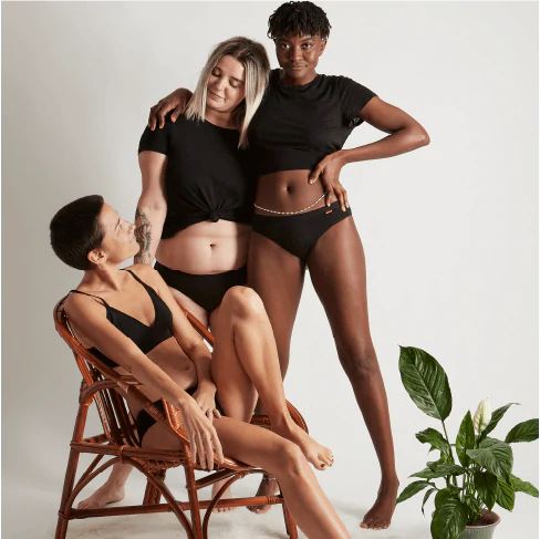 WUKA Basics Hipster Medium Flow i svart bomull, tre modeller poserer sammen i studio