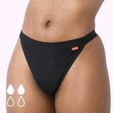 WUKA Basics™ Thong Light Flow i svart bomull på en modell, med to fylte og to tomme dråper