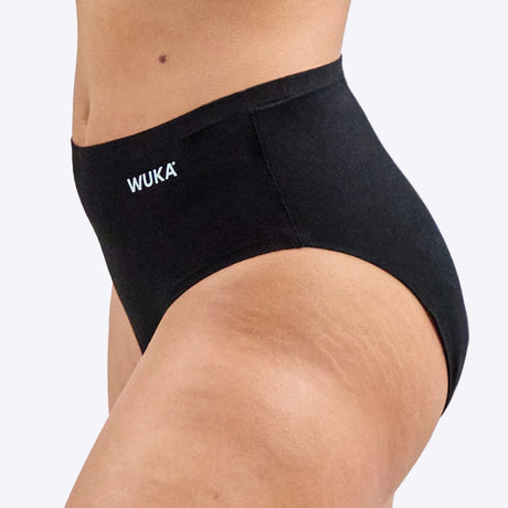 Wuka Stretch Cotton Midi Brief Heavy Flow i svart bomull, sett fra siden på en kvinnekropp med WUKA-logoen synlig