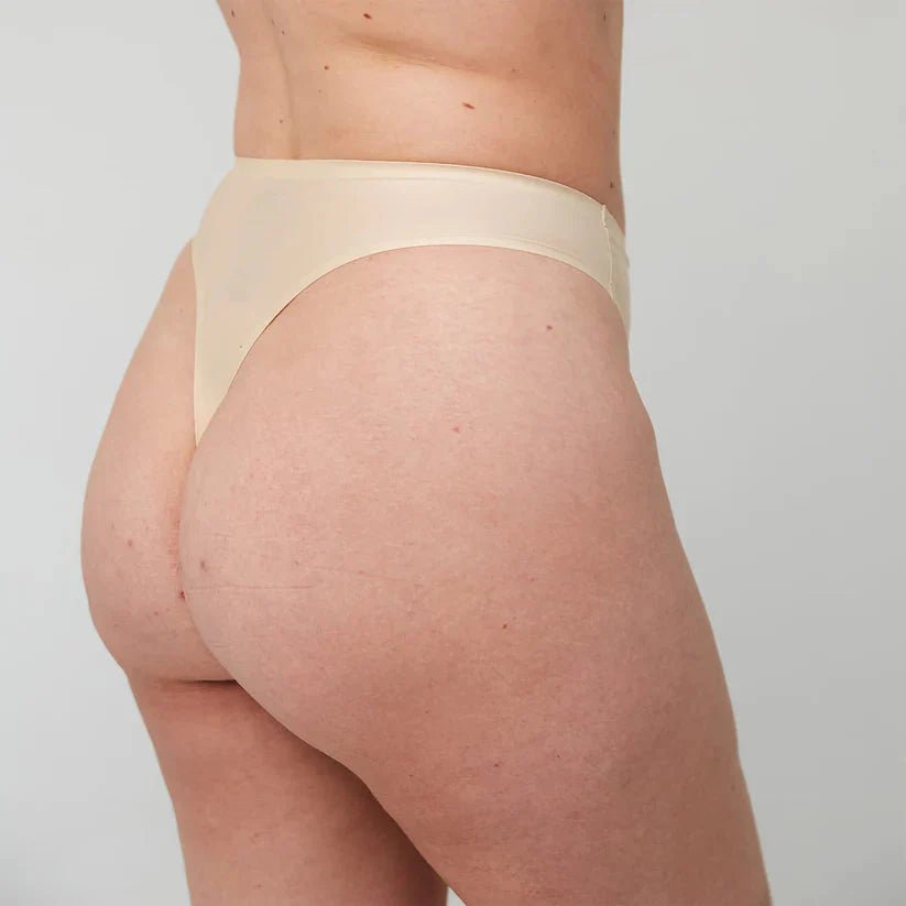 WUKA Stretch Thong for Light-Medium Flow i nude, i bruk på modell, sett fra siden