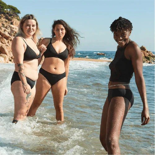 WUKA Swim Bikini Brief Light Flow Svart i stoff, tre kvinner i vannkanten på en strand