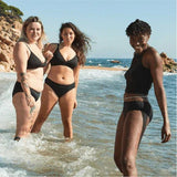 WUKA Swim Bikini Brief Light Flow Svart i stoff, tre kvinner i vannkanten på en strand